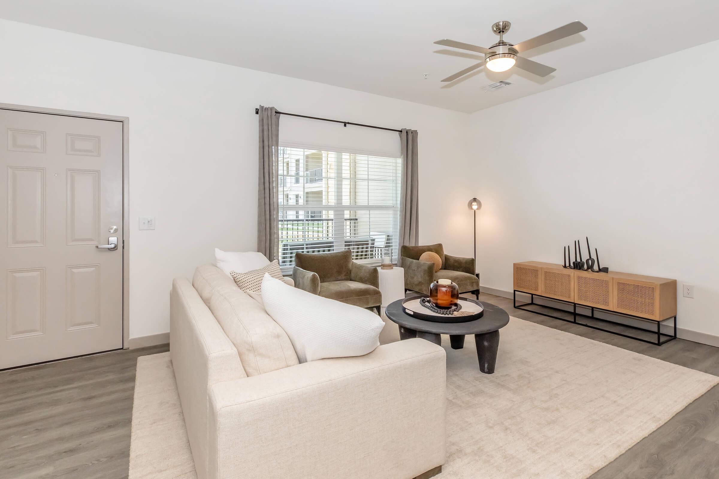 a living room filled with furniture and a large window