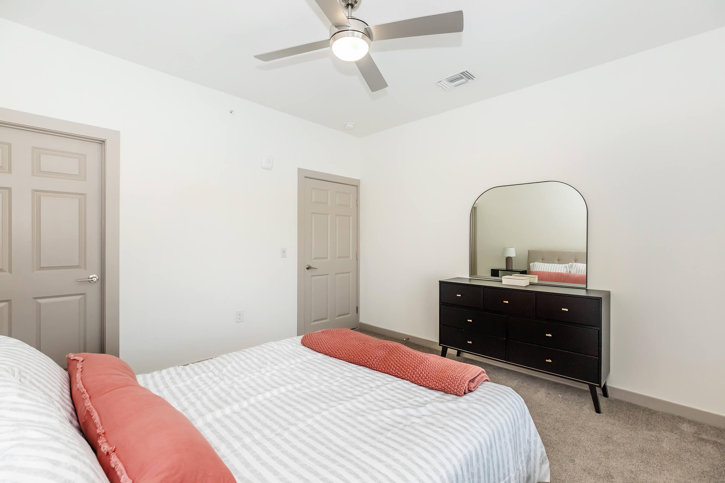 a bedroom with a bed and desk in a small room