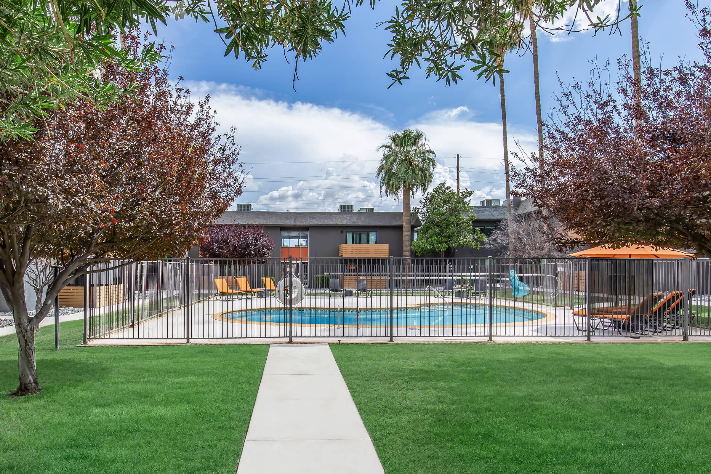 a large lawn in front of a fence