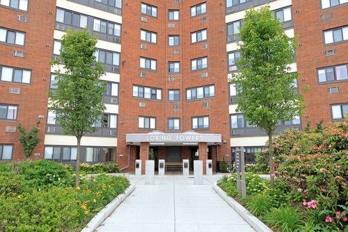 a large brick building with grass and trees