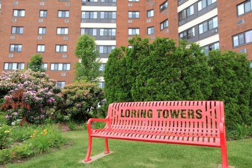 a wooden park bench sitting in front of a building