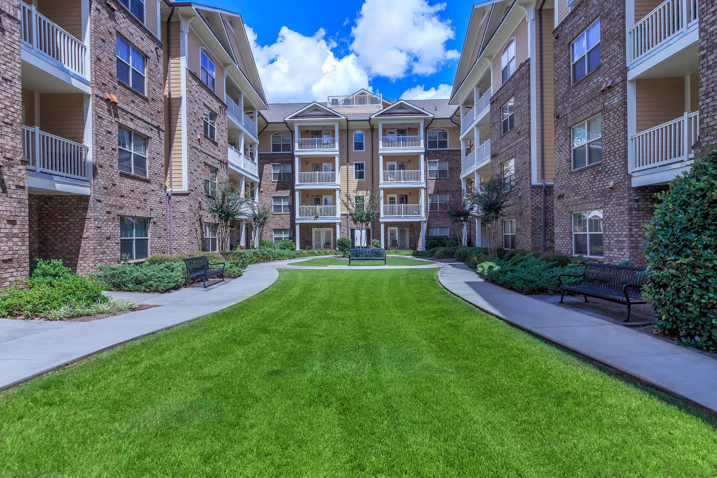 a large lawn in front of a brick building