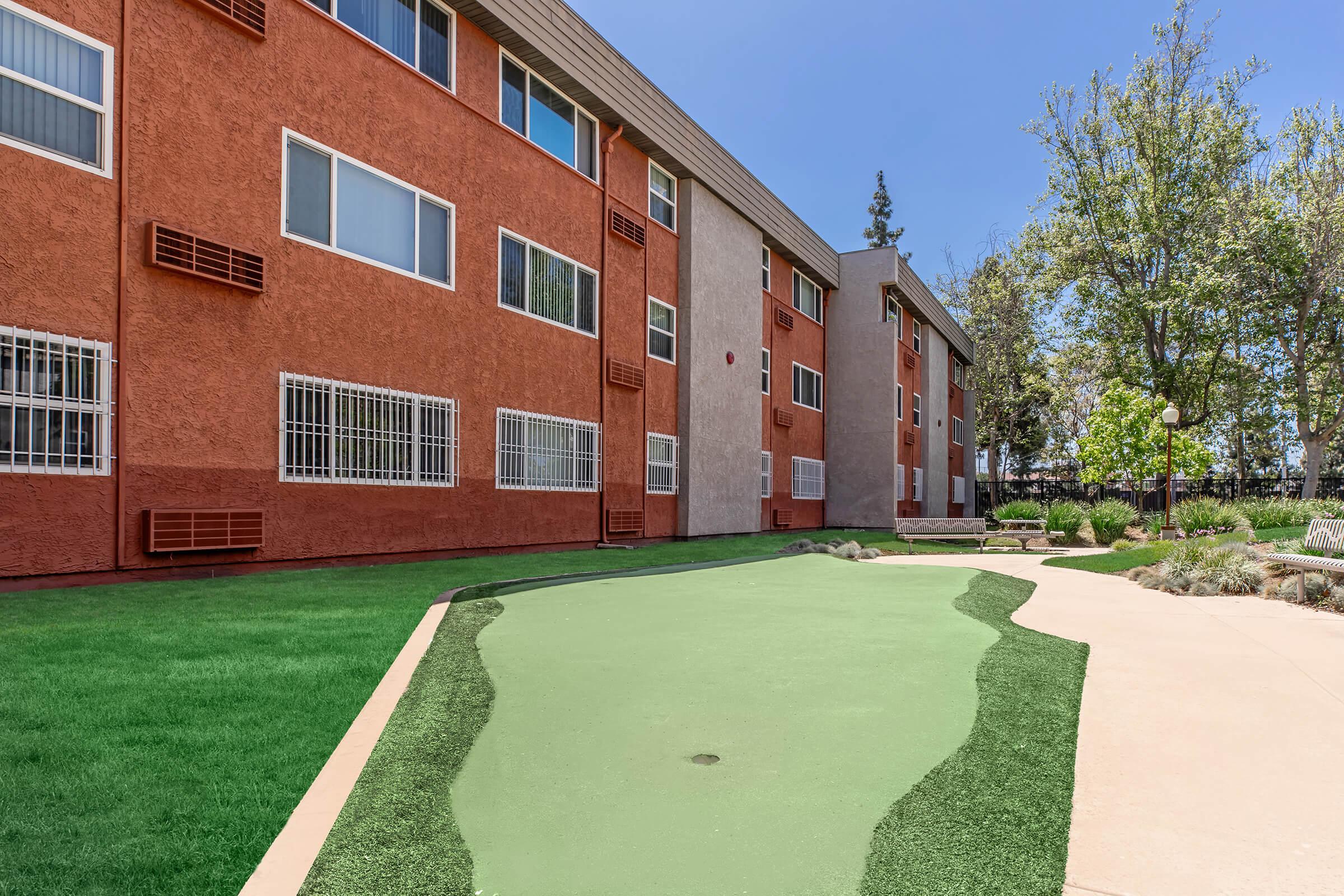 a large lawn in front of a brick building