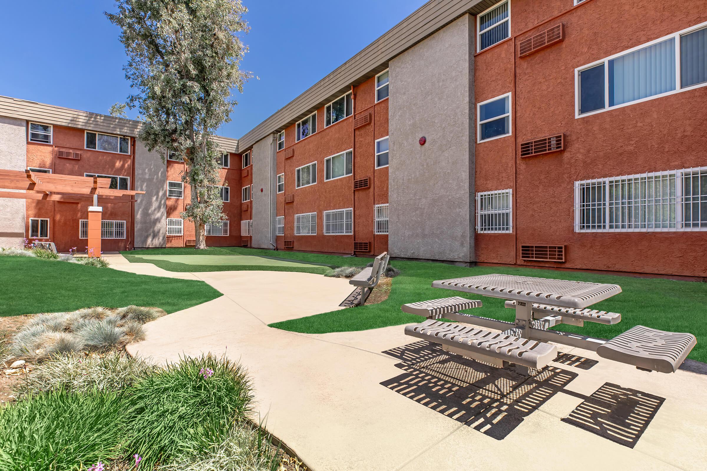 a large lawn in front of a brick building