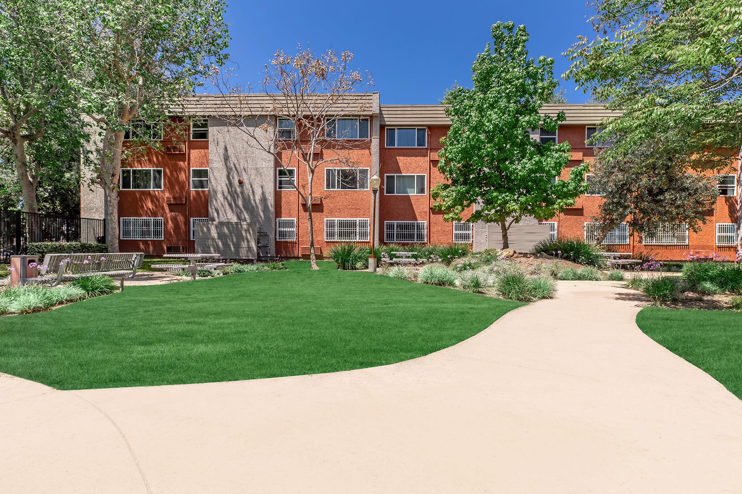 a large lawn in front of a brick building