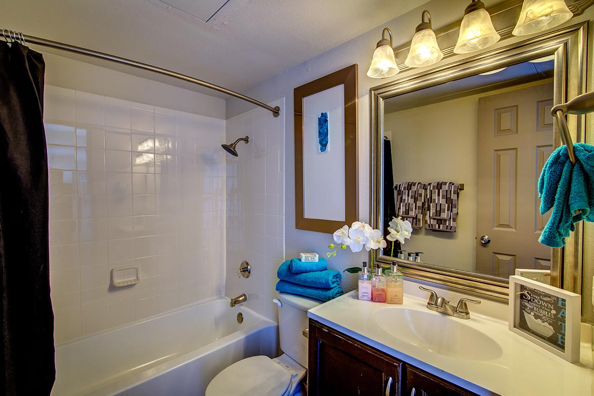 a furnished bathroom with wooden cabinets