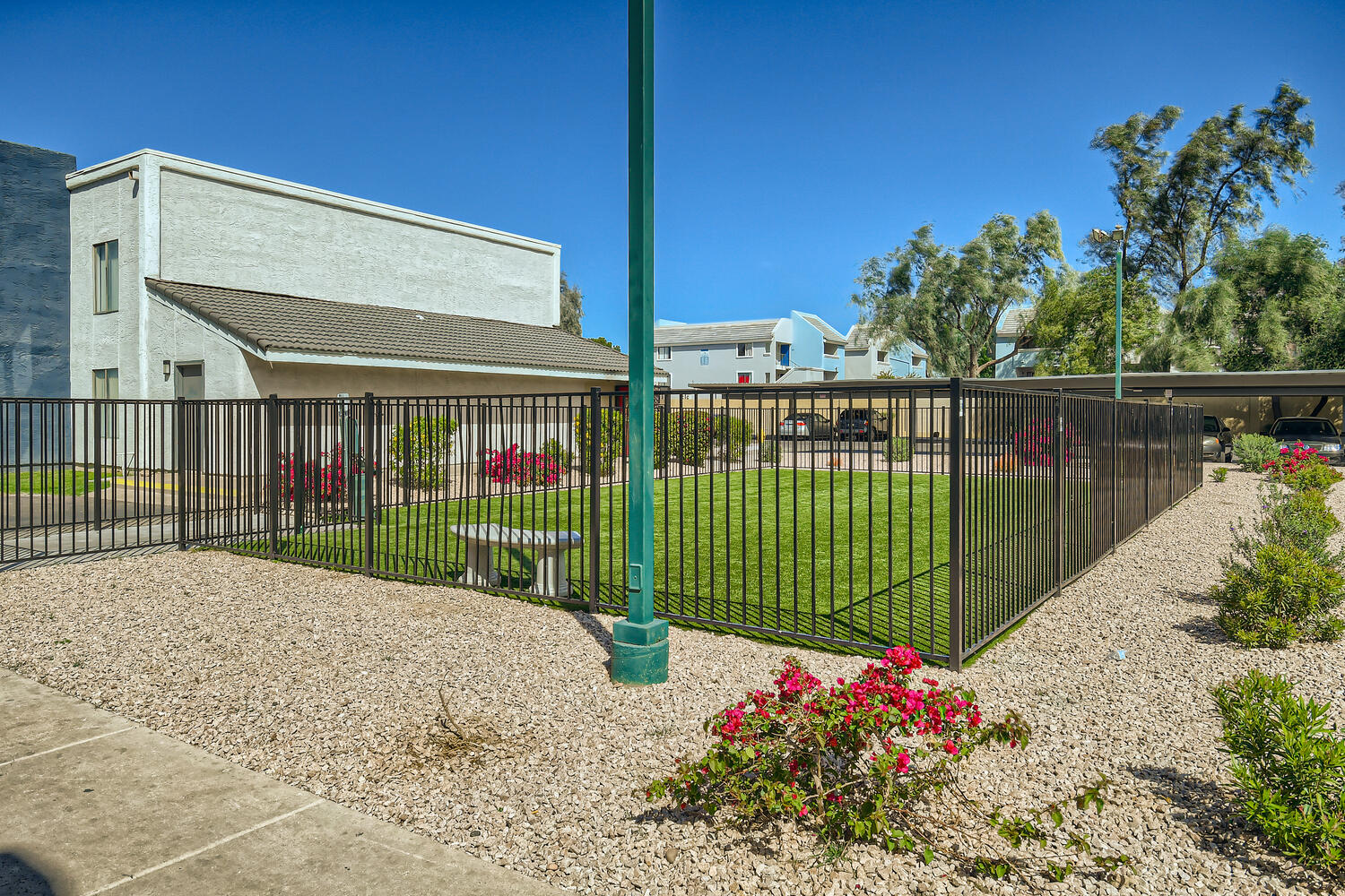 Glendale, AZ apartments with a fence in front of a building and grass