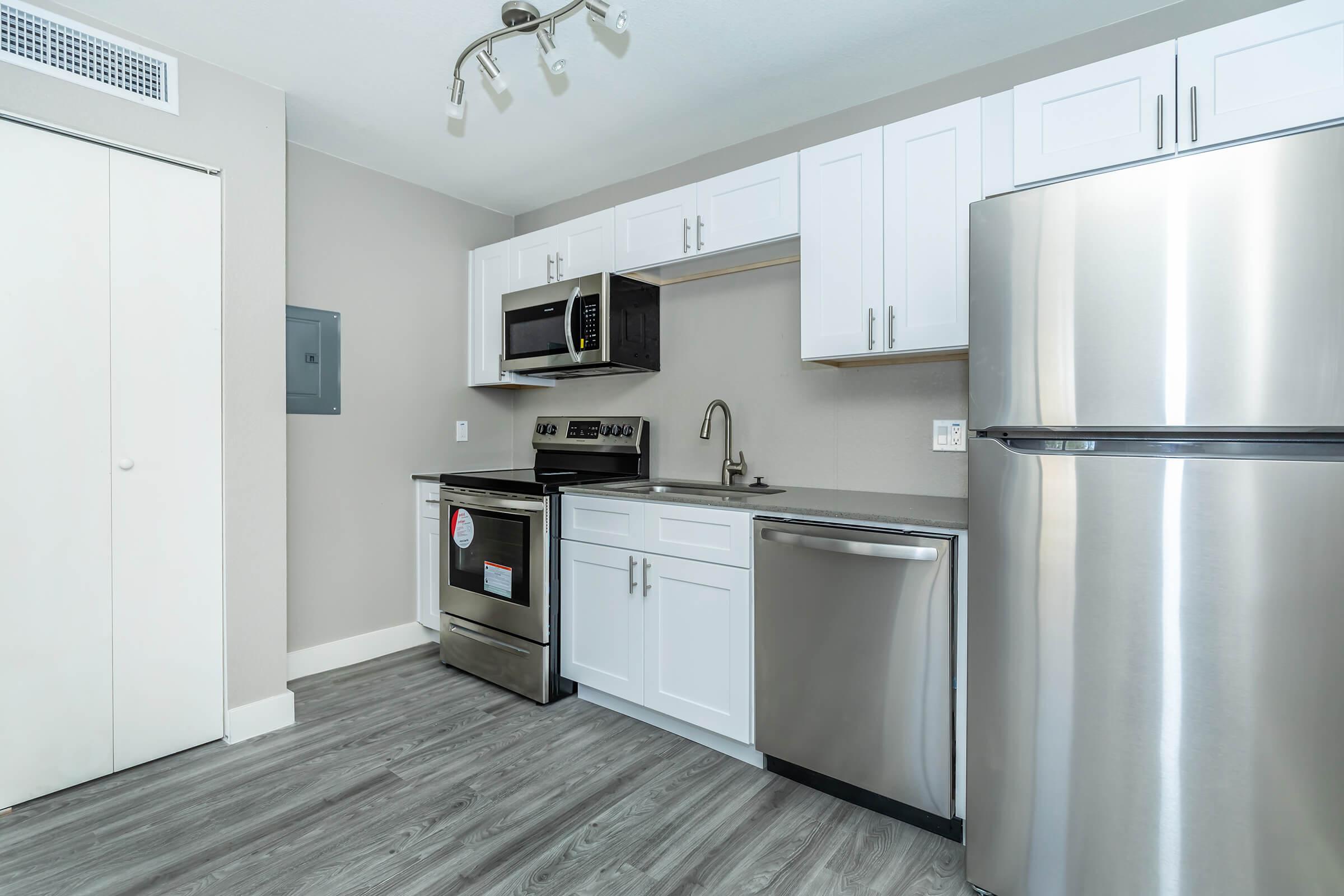 Brand new modern kitchen with stainless steel appliances and white shaker cabinets