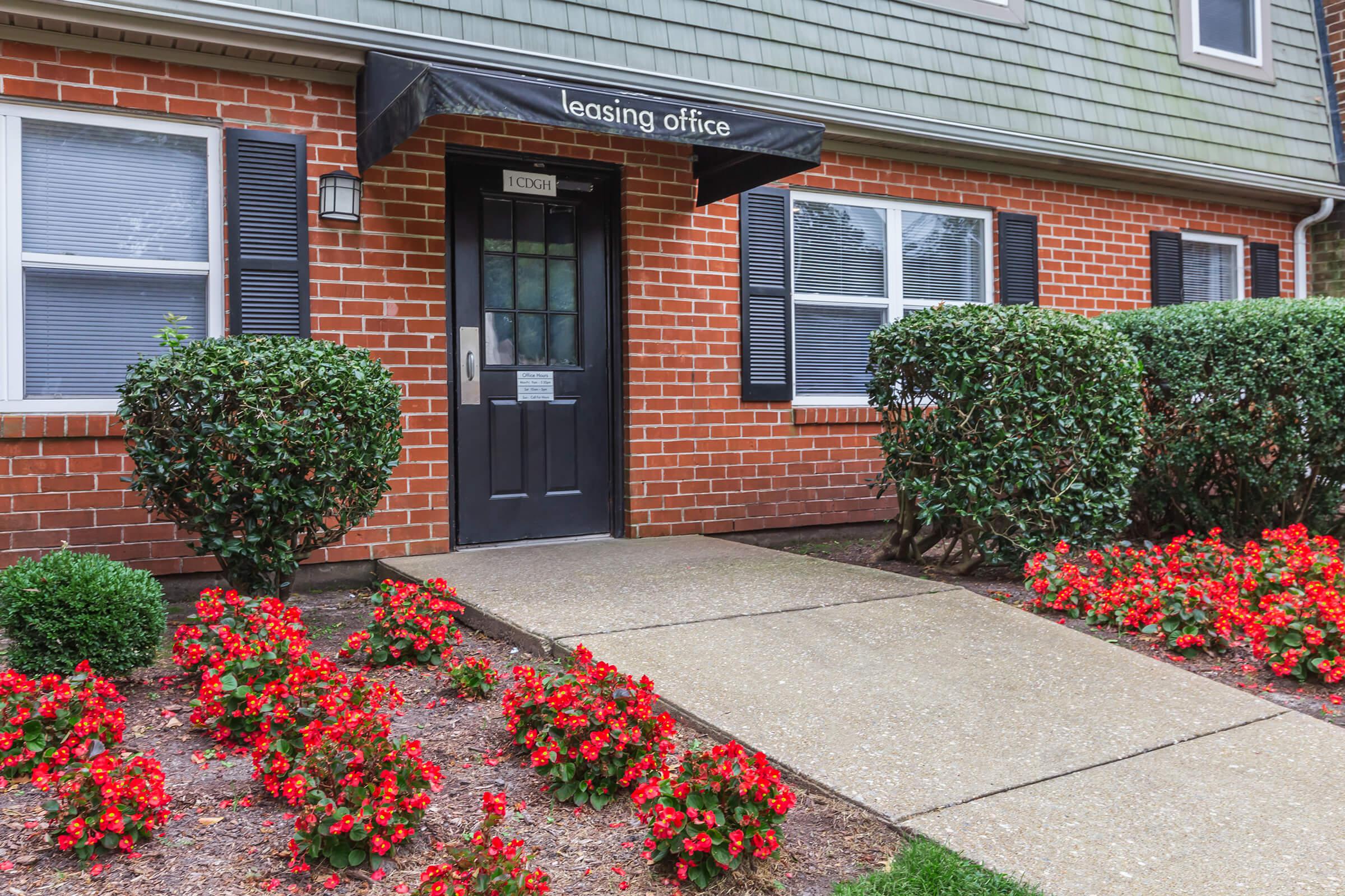 a house with bushes in front of a brick building