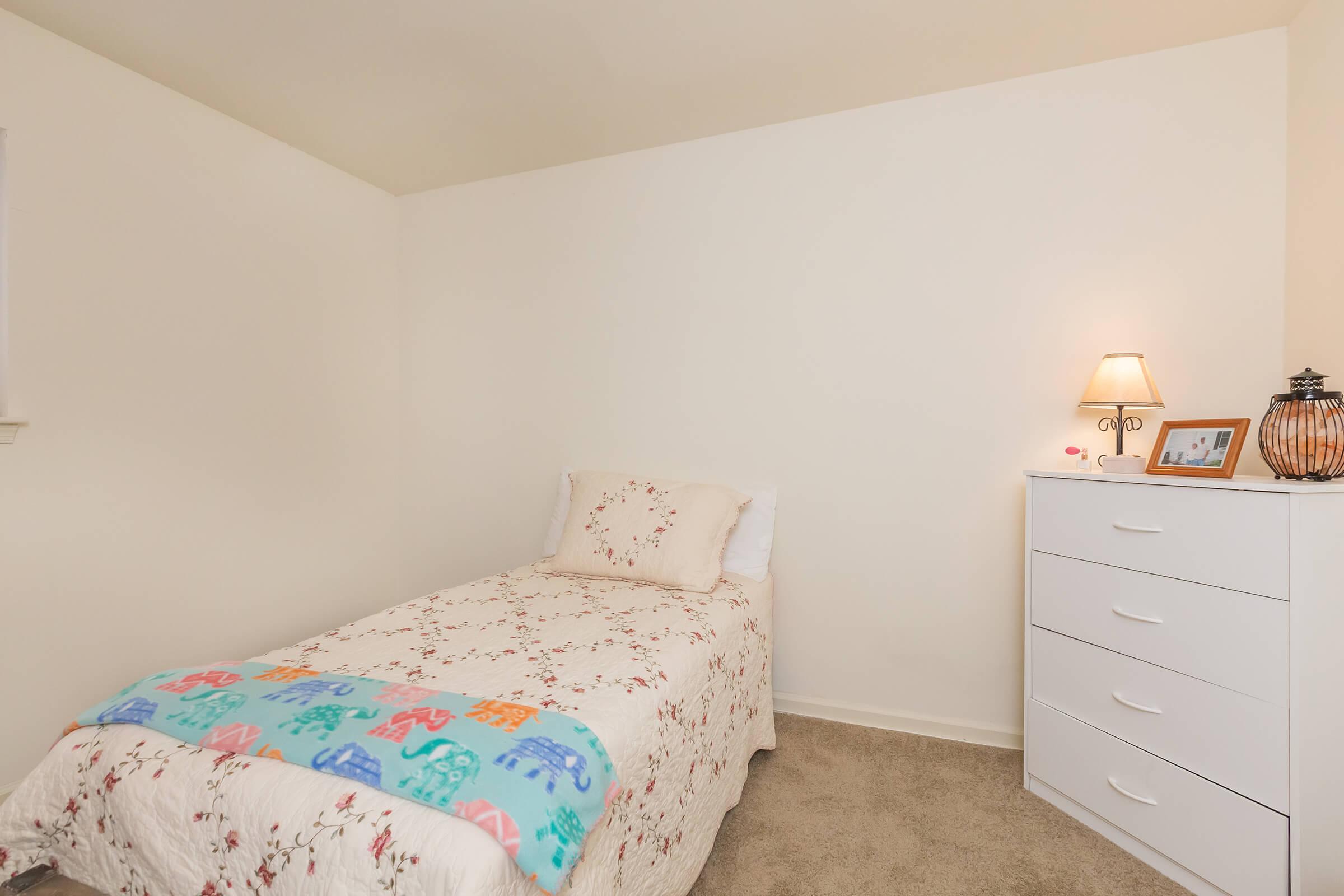 a bedroom with a bed and desk in a small room