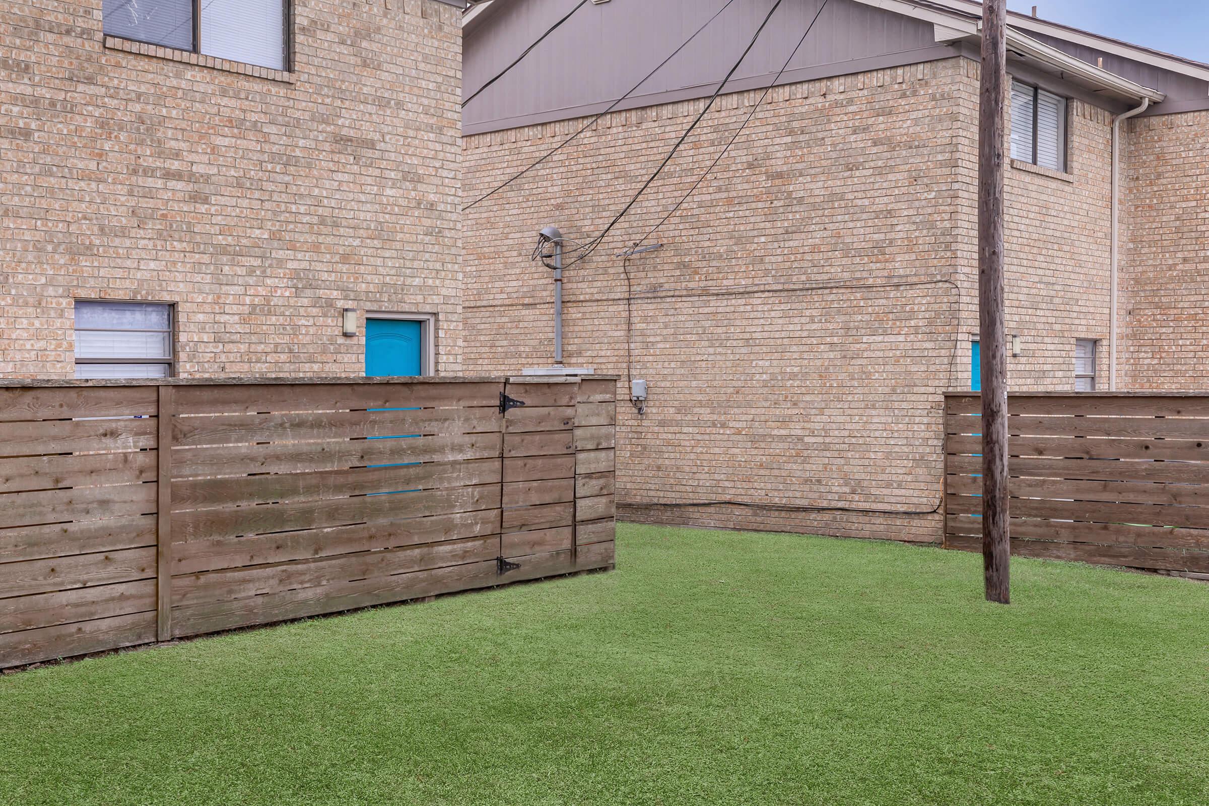 a house with a lawn in front of a brick building