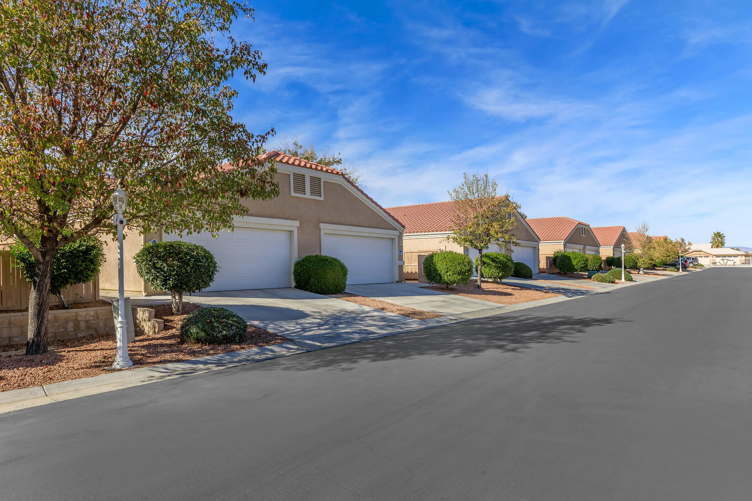 an empty road with trees on the side of a house