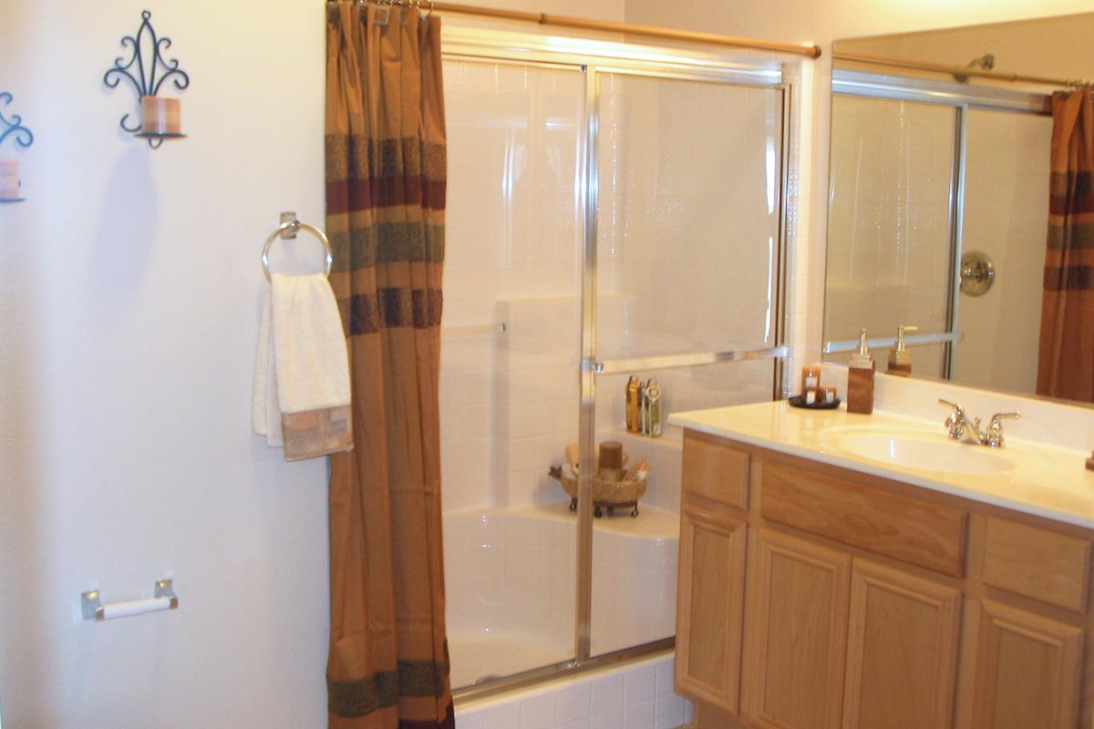 a white sink sitting next to a shower