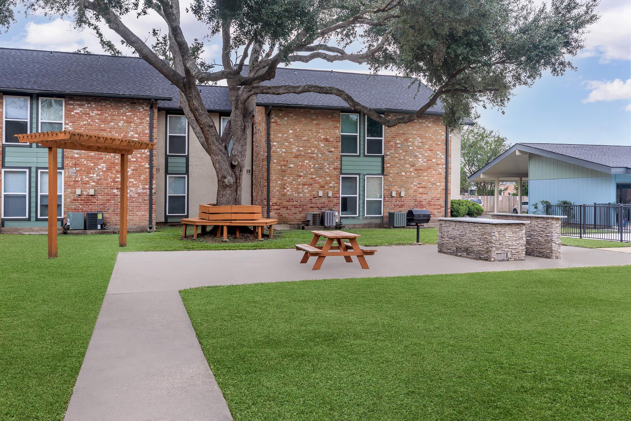 a house with a lawn in front of a brick building