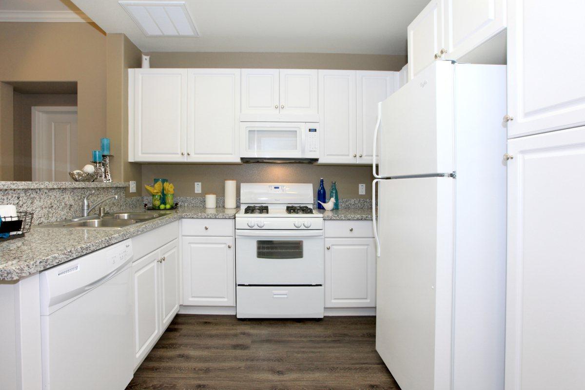 Kitchen with white appliances with granite countertops