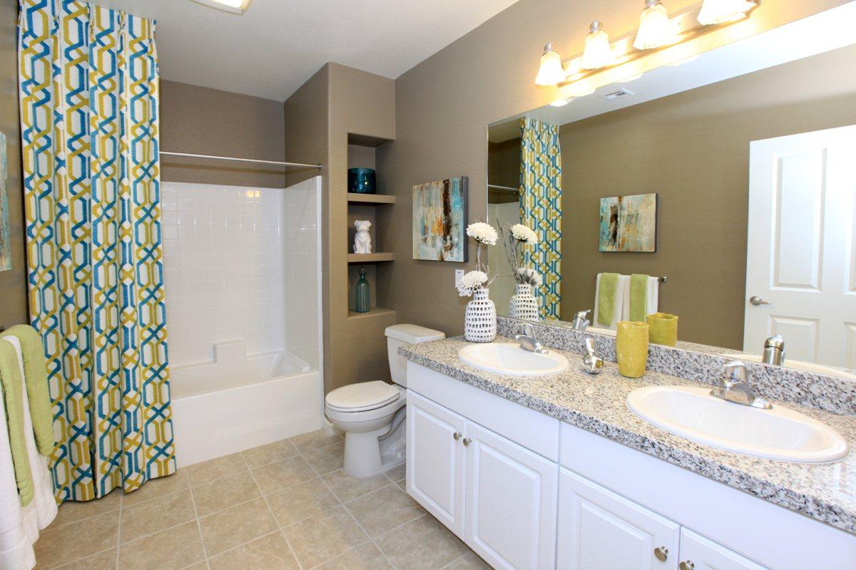 Bathroom with two sinks and green shower curtain