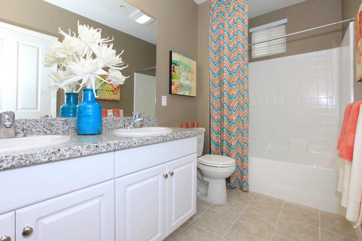 Bathroom with two sinks and a blue vase