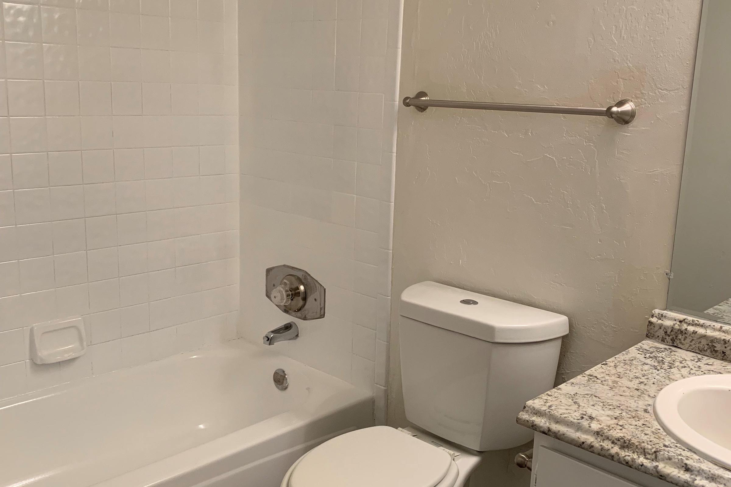 a white sink sitting under a mirror