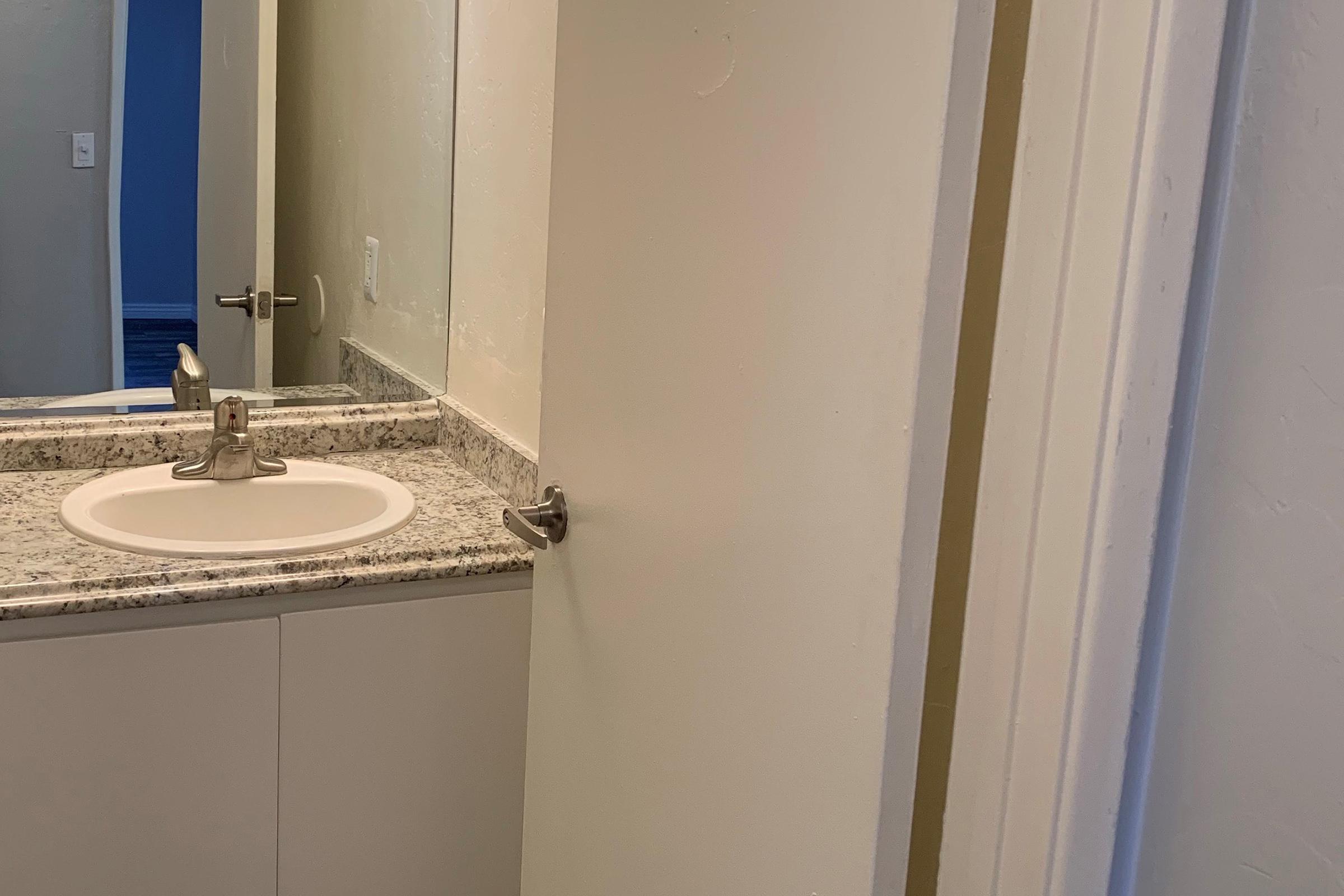 a white sink sitting under a mirror
