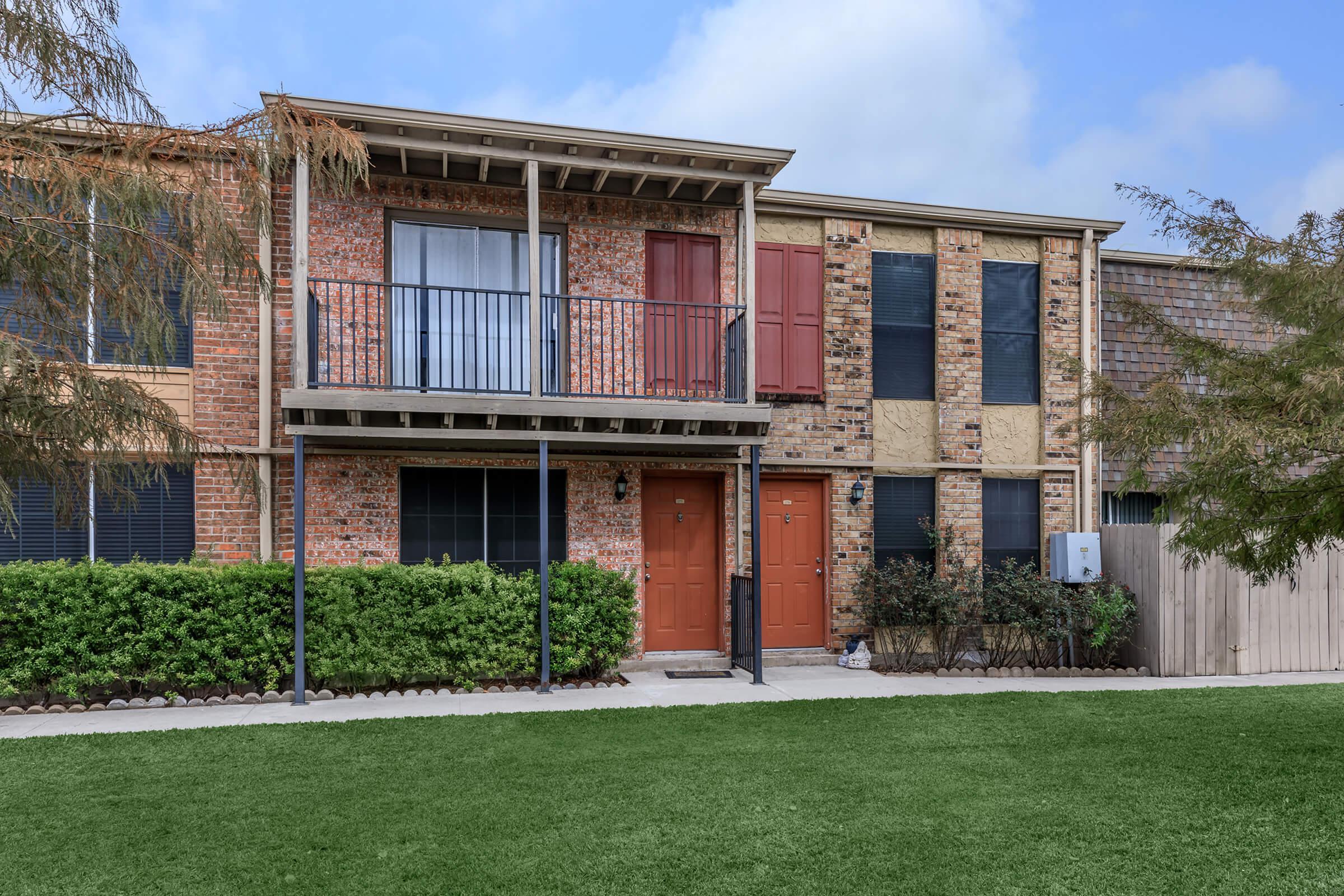 a large lawn in front of a brick building