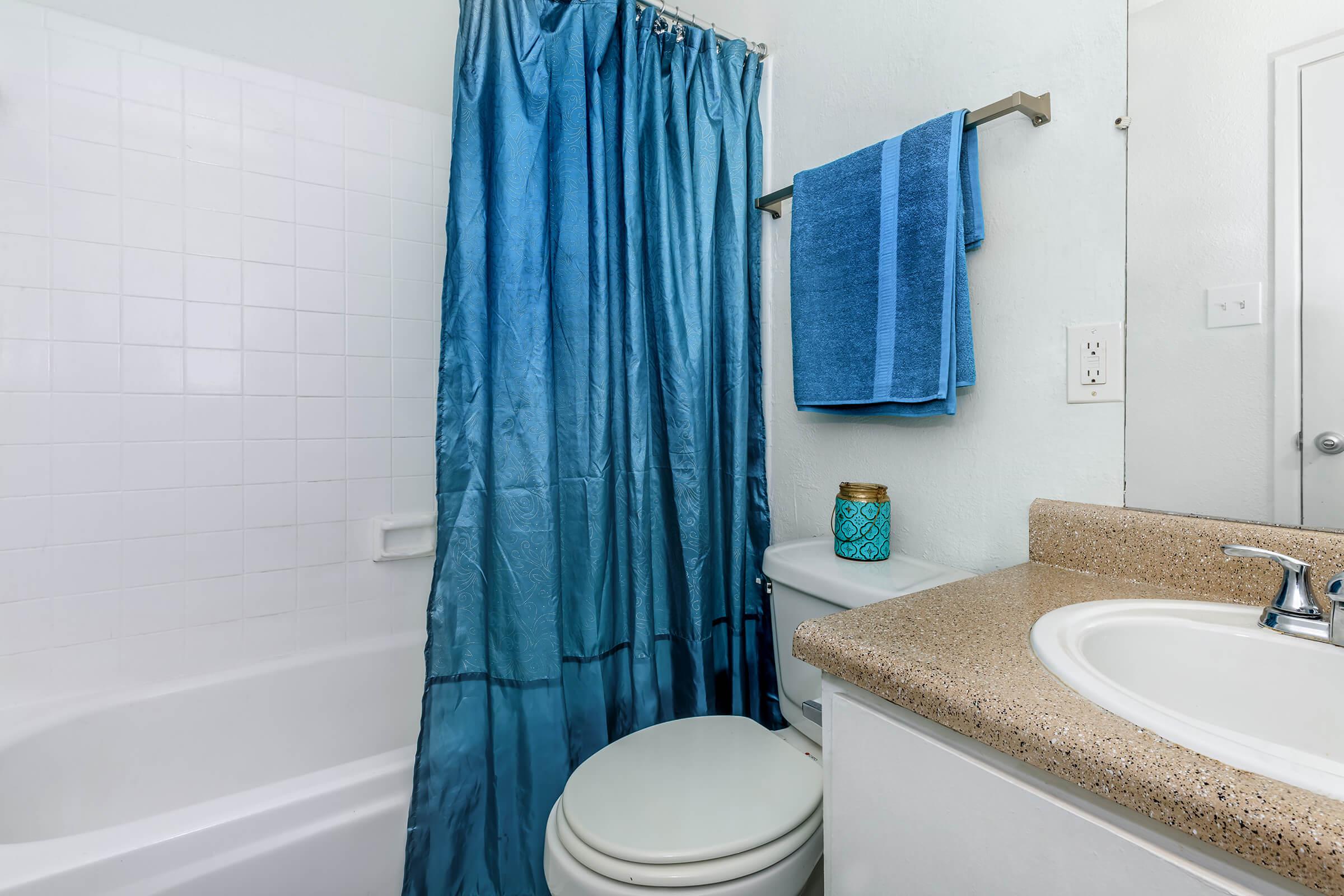 a shower curtain with a white tub sitting next to a sink