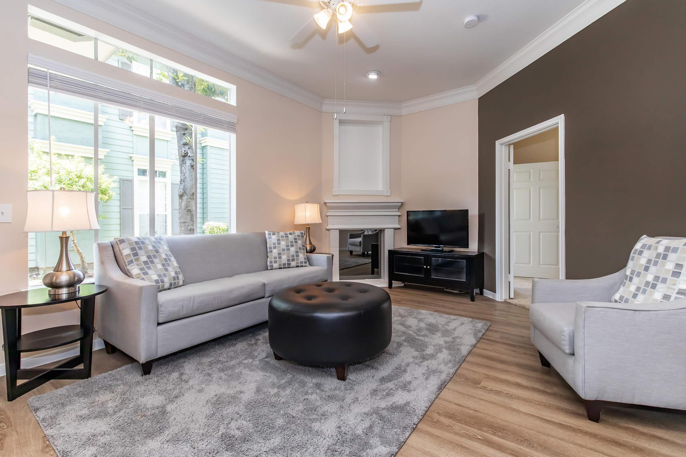 a living room filled with furniture and a large window