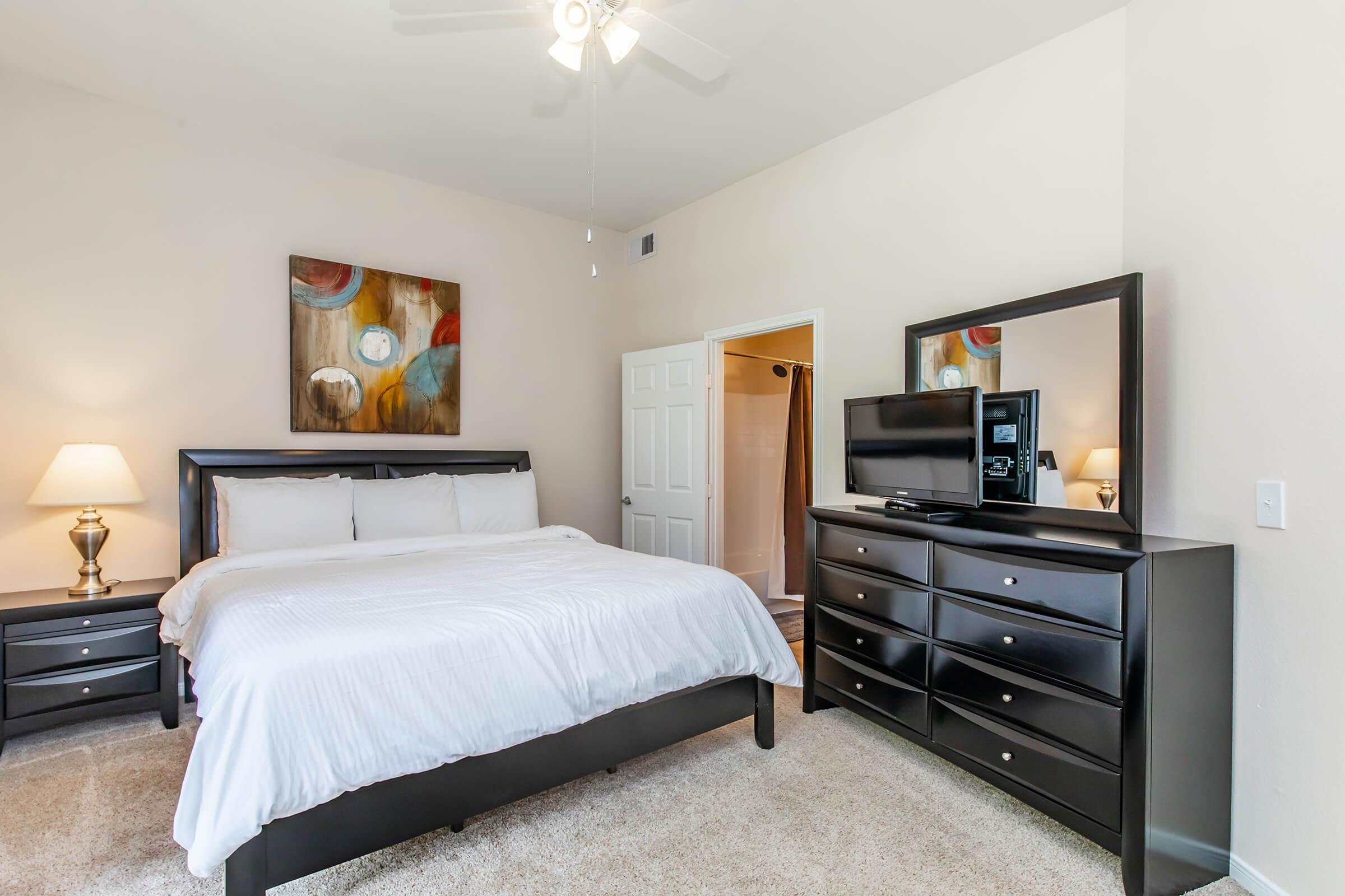 a bedroom with a bed and desk in a room