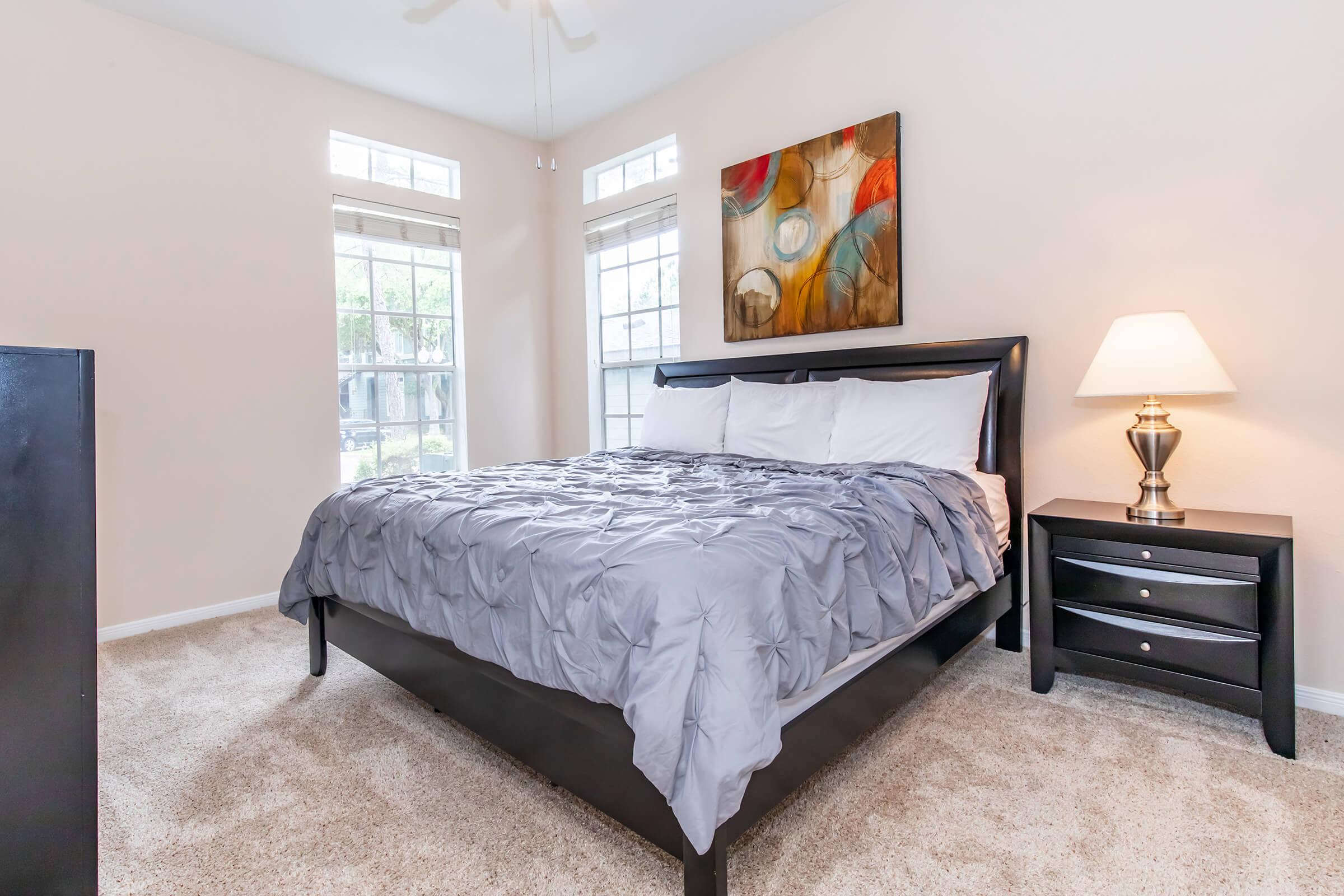 a bedroom with a bed and desk in a room