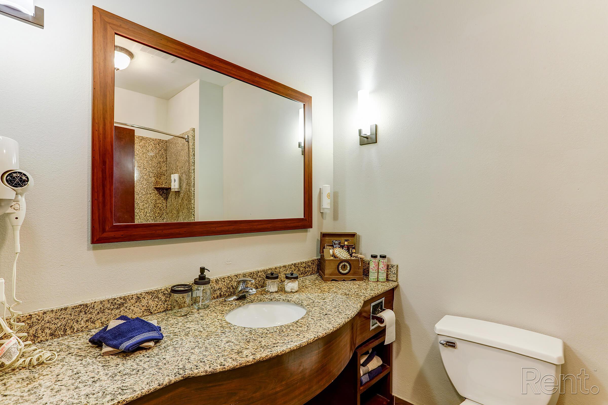 a bedroom area with a sink and a mirror