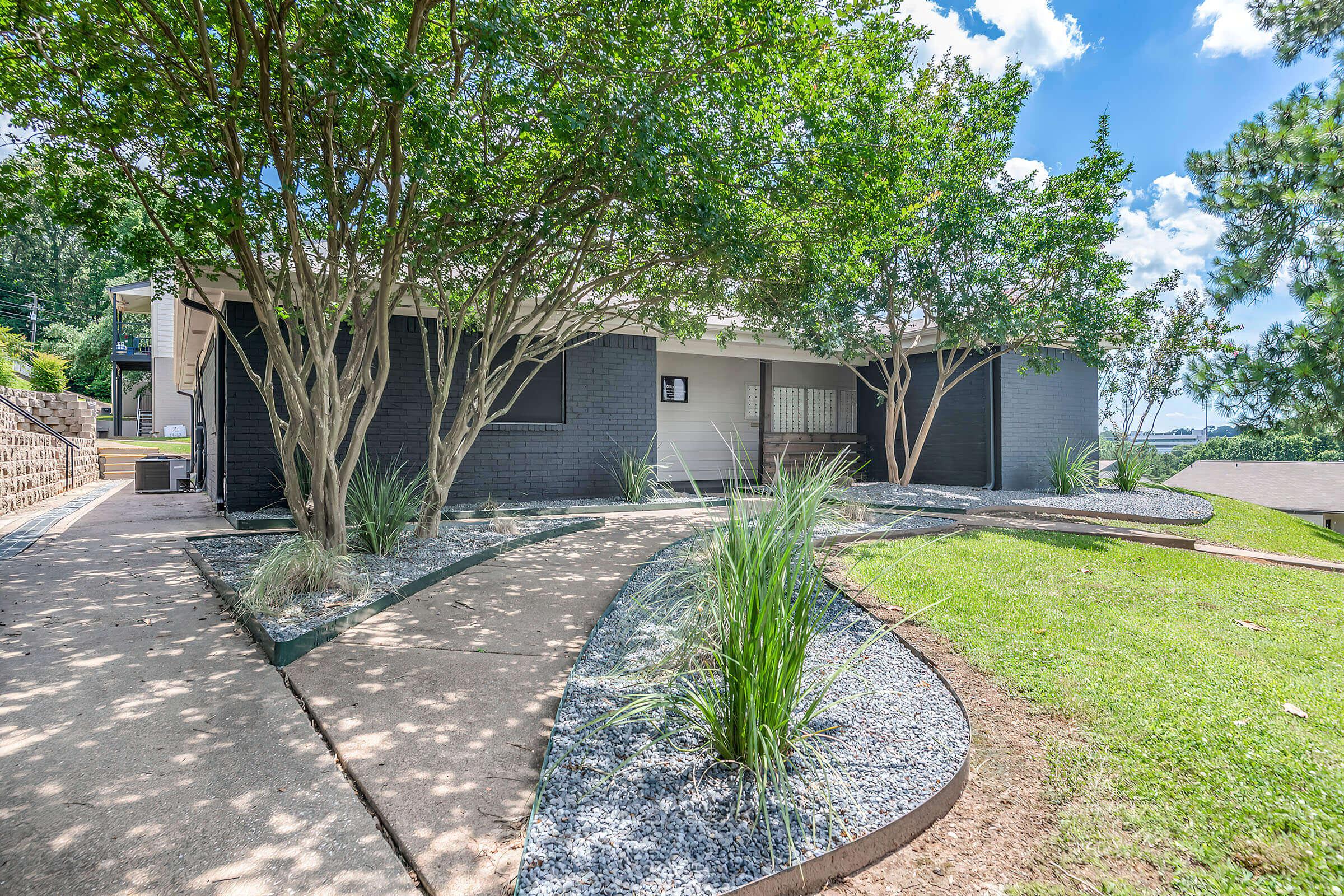 a path with trees on the side of a house