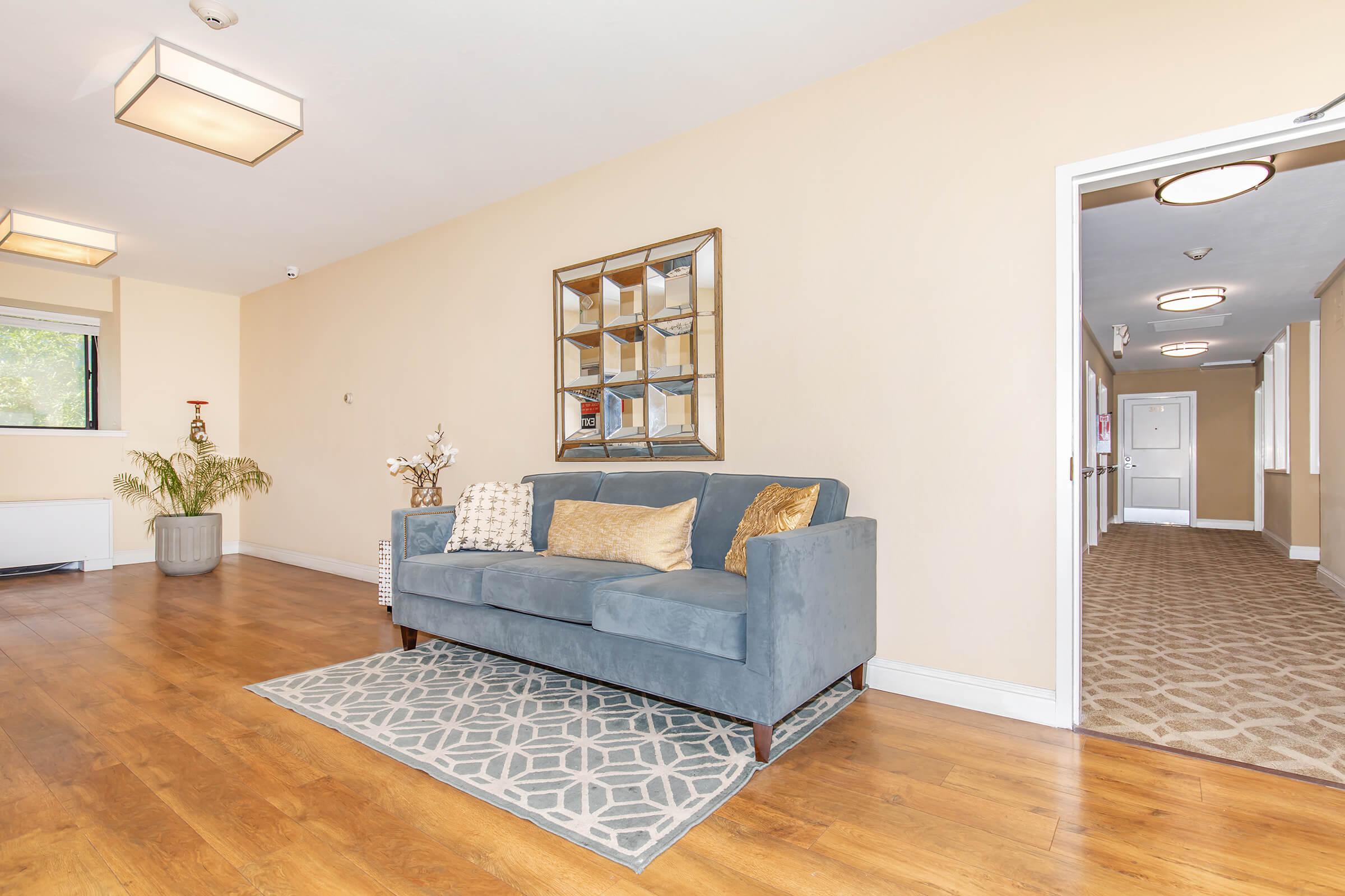 Community room with wooden floors and blue couch