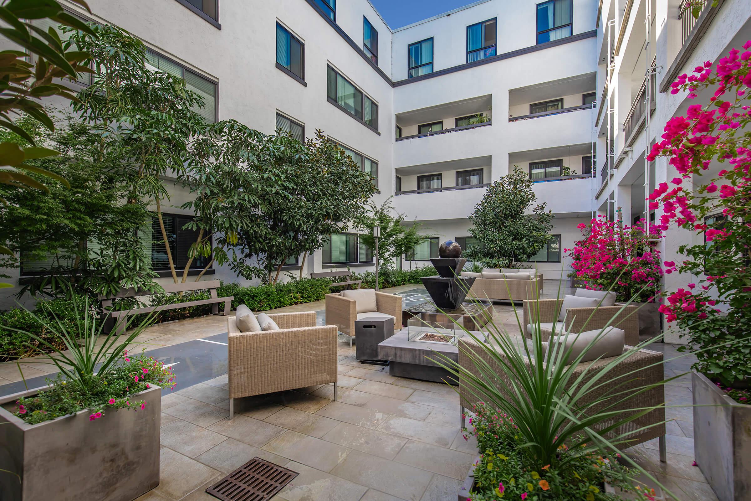 1825 Mission courtyard filled with plants and couches