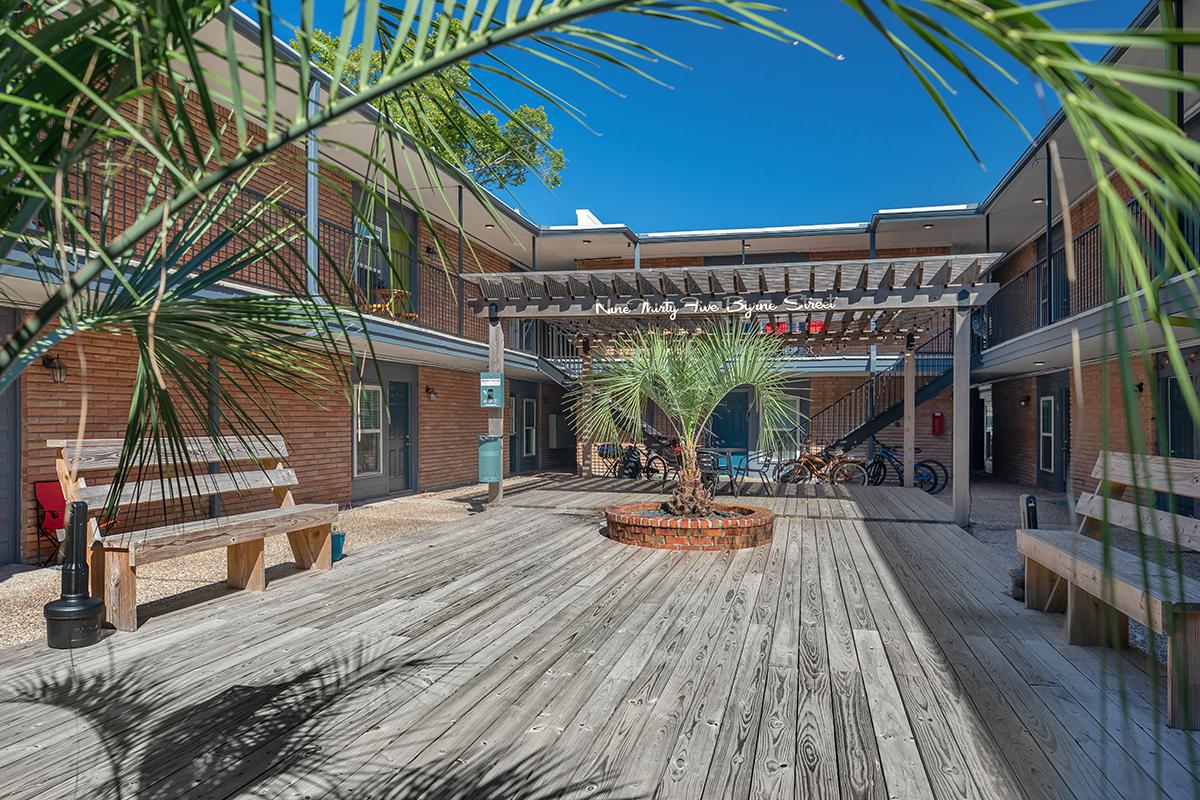 a building with palm trees and a fence