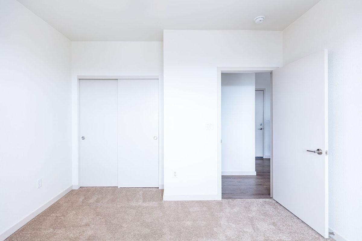 A minimalist room with light-colored walls and beige carpet.