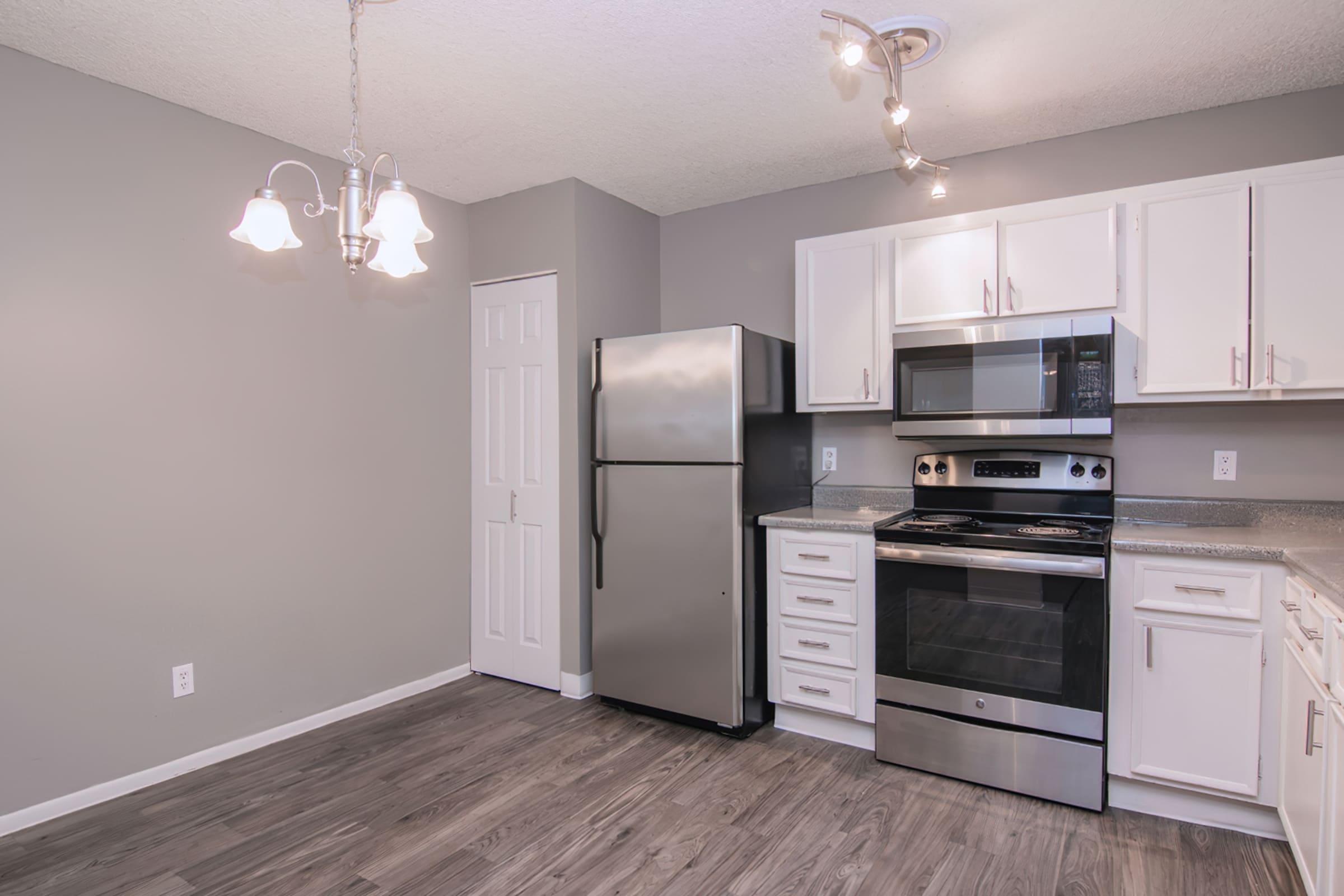 a large kitchen with stainless steel appliances and wooden cabinets