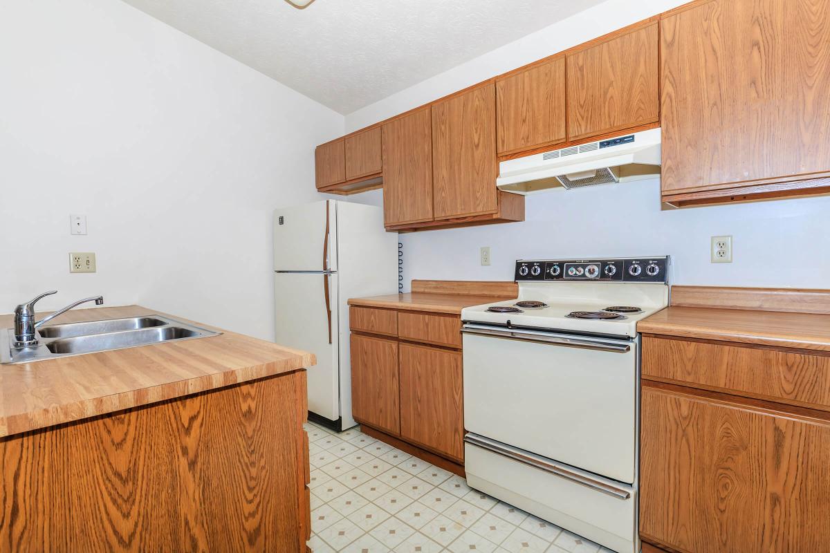 a kitchen with wooden cabinets and a refrigerator