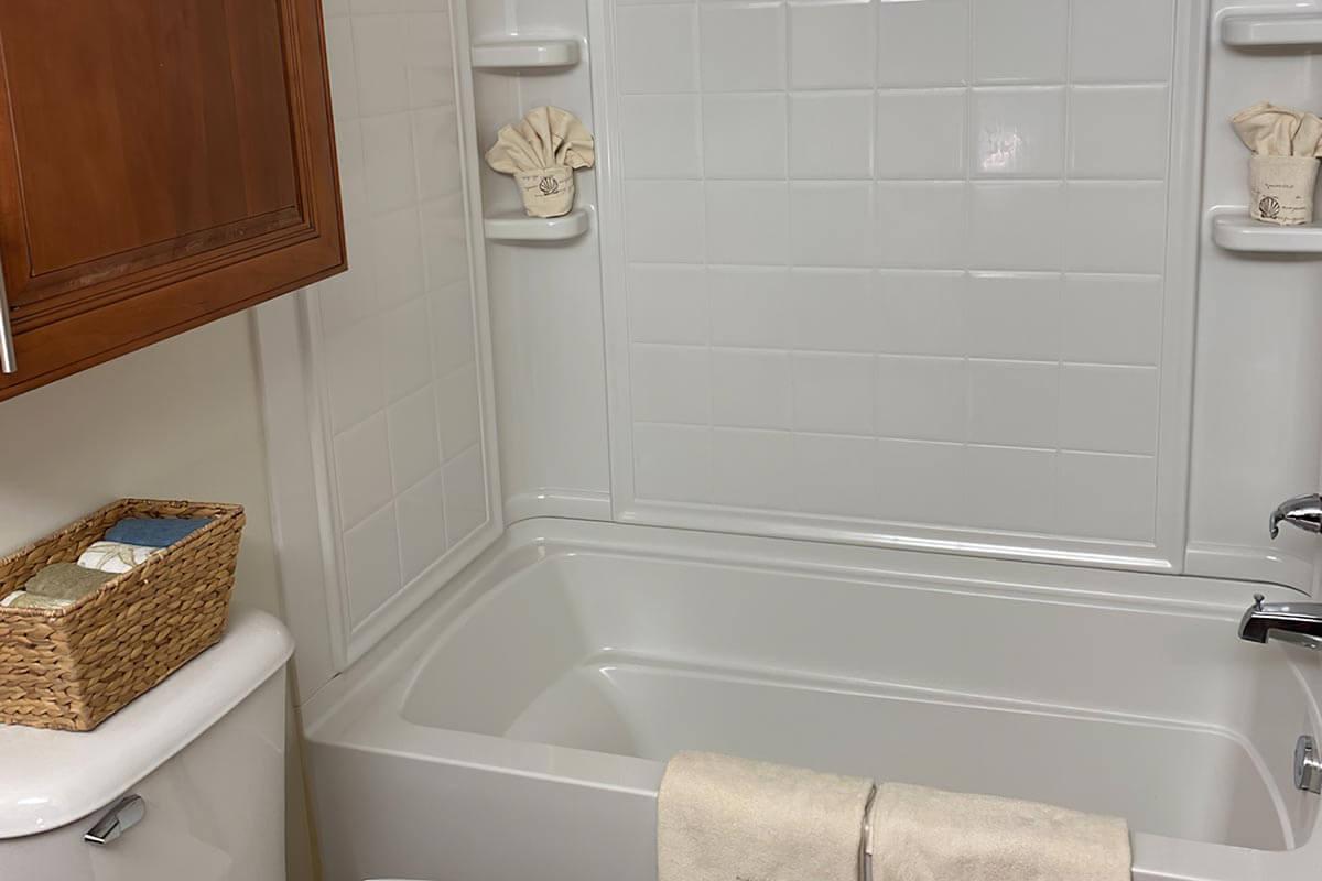 a sink sitting under a mirror next to a tub