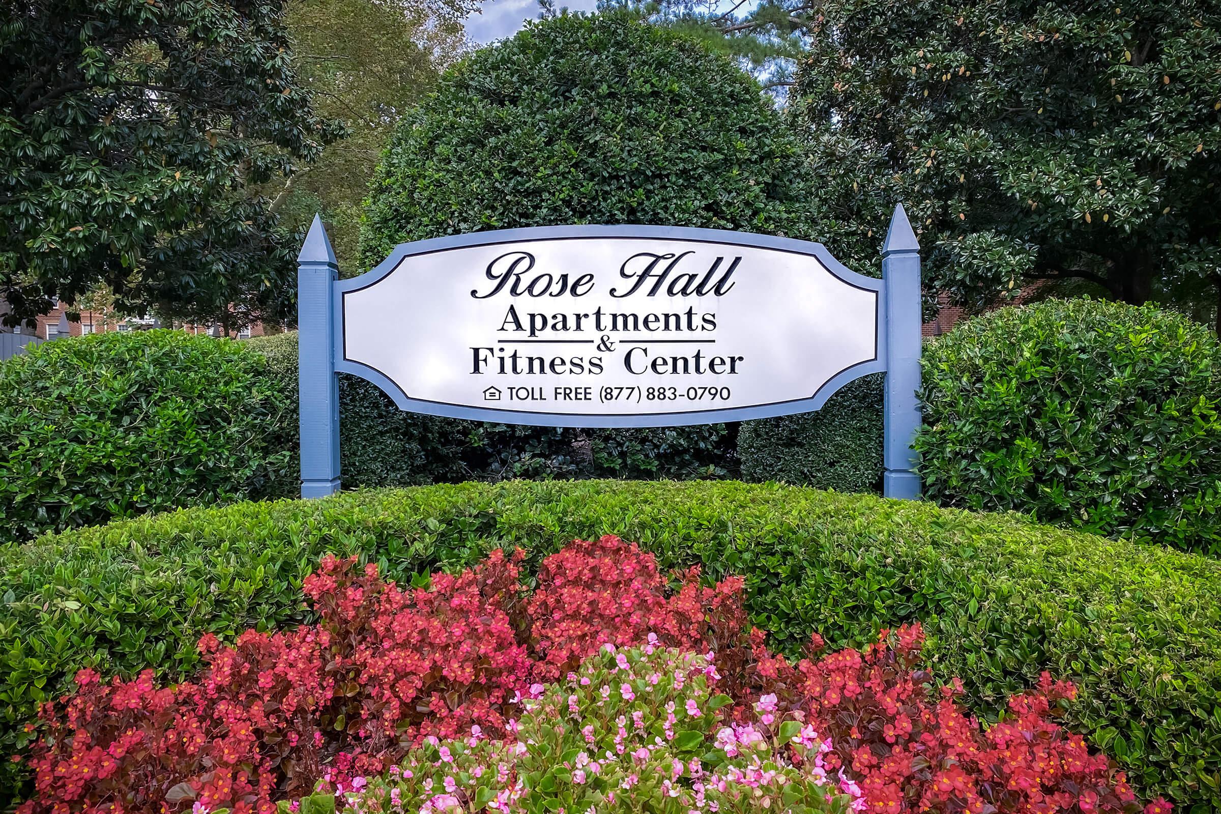 a sign above a flower garden