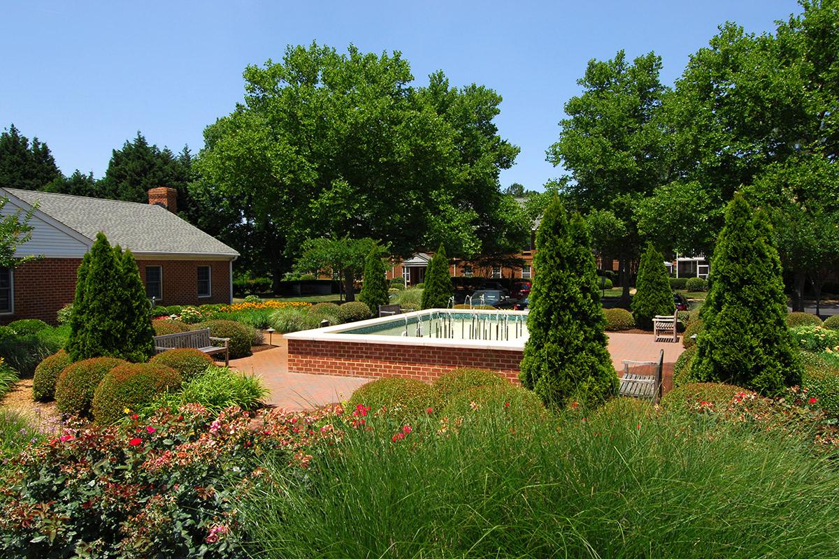 a house with bushes in front of a tree