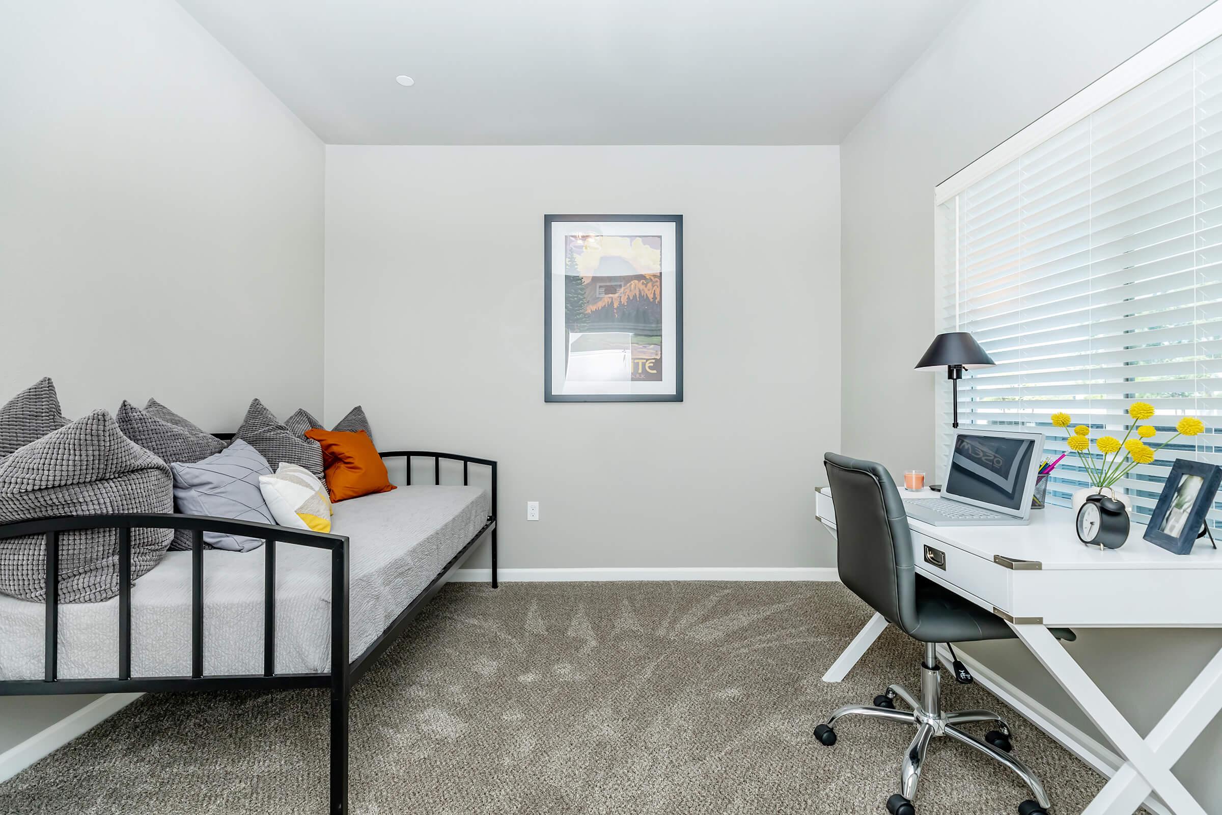 a living area with a desk and chair in a room