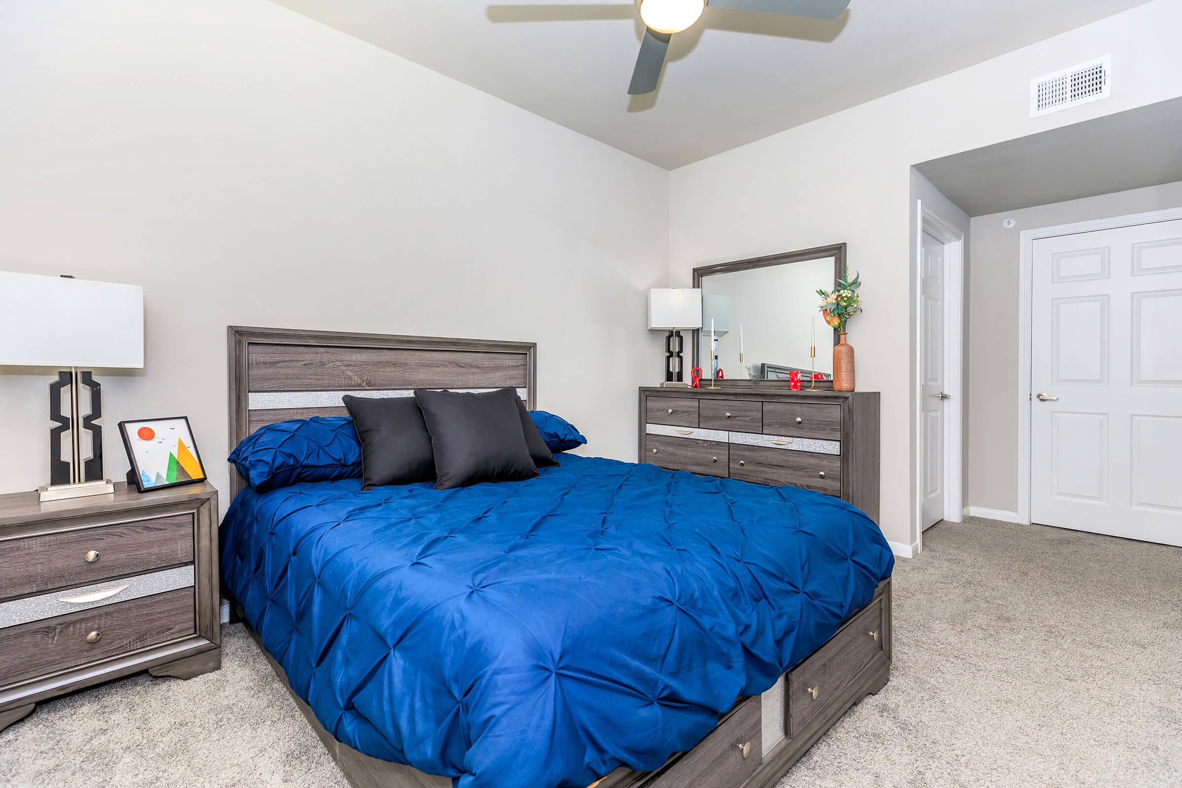 a bedroom with a bed and desk in a room