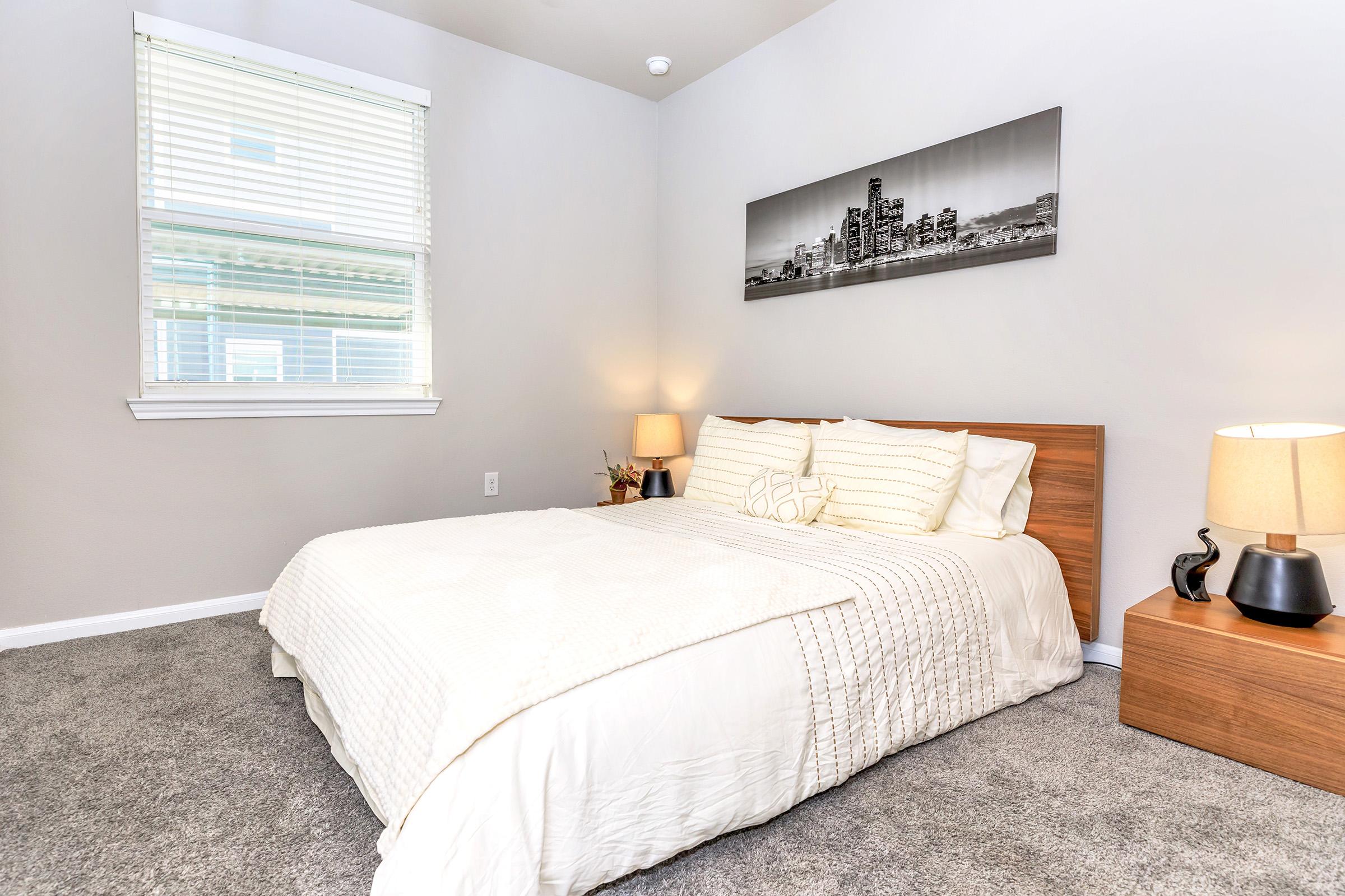 a bedroom with a bed and desk in a hotel room