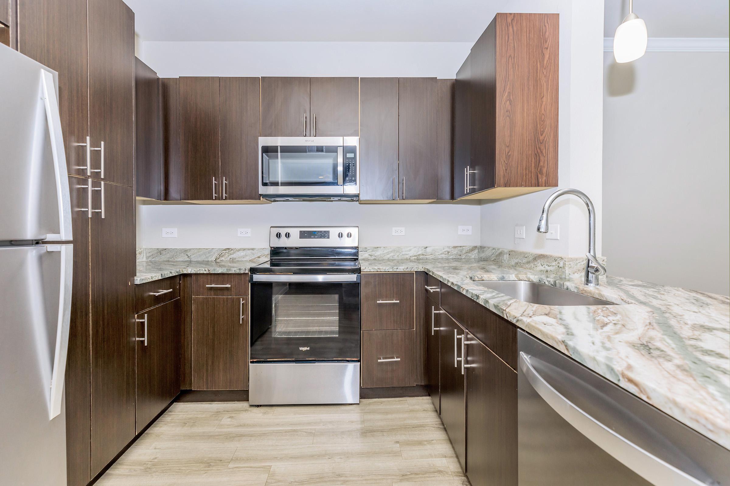 a large kitchen with stainless steel appliances and wooden cabinets