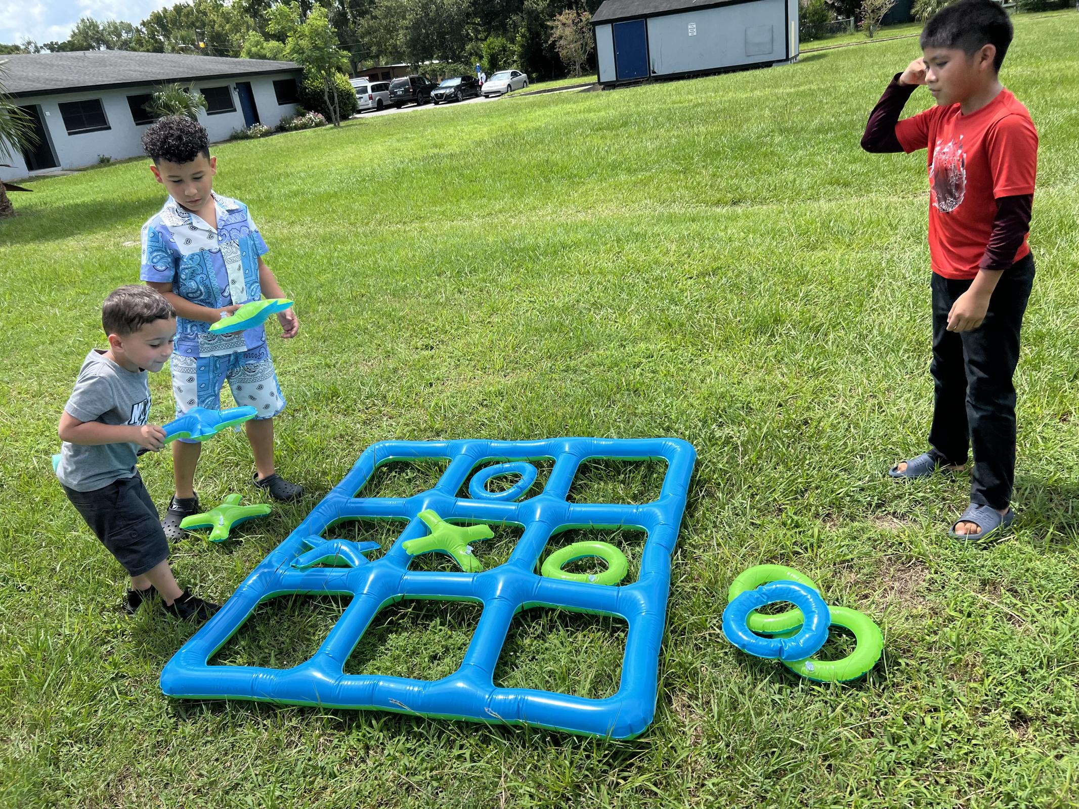 a young boy playing with a blue ball on the field