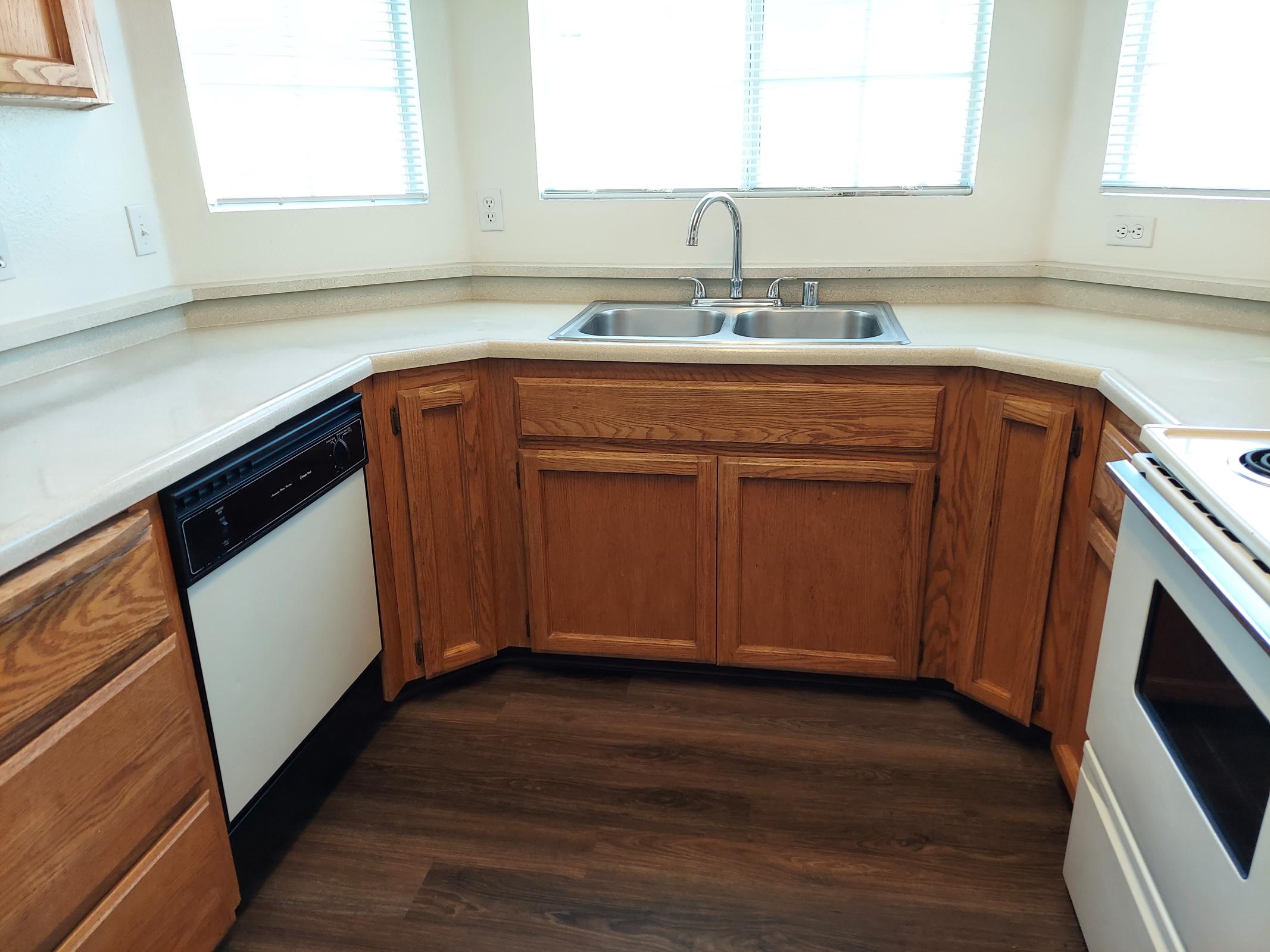 a kitchen with wooden cabinets and a window