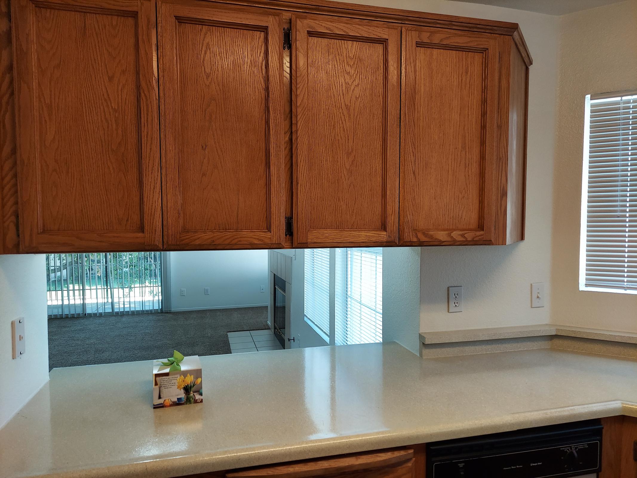 a kitchen with wooden cabinets and a microwave