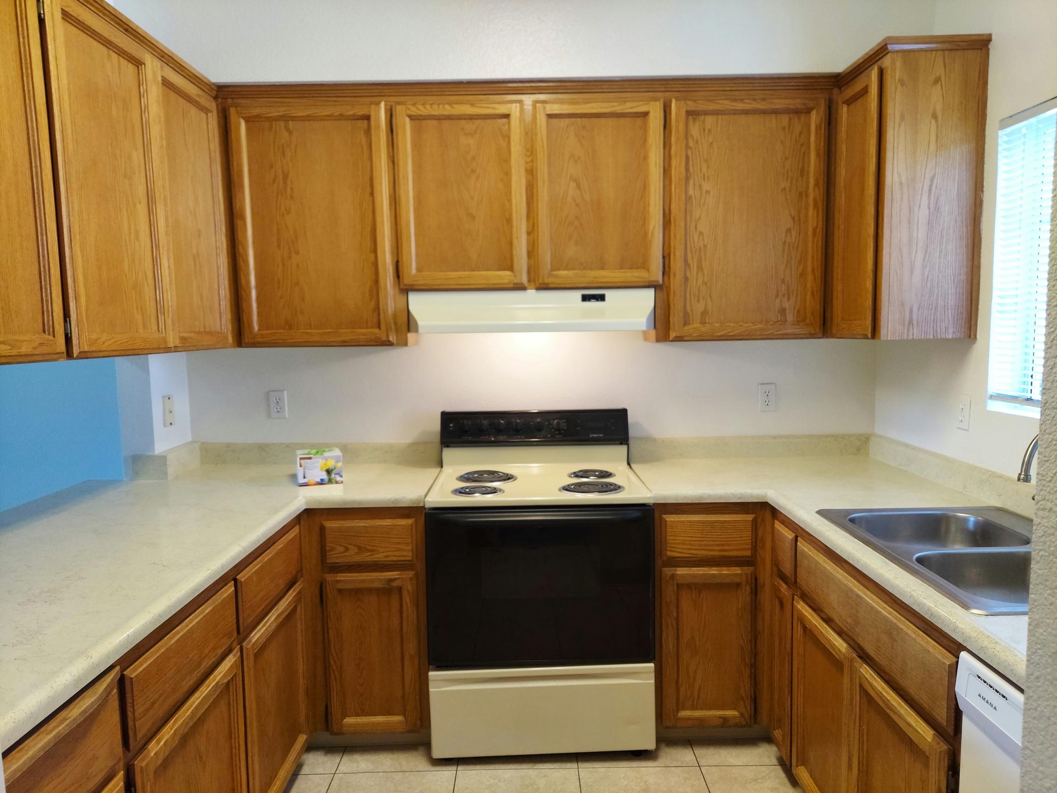 a kitchen with wooden cabinets and a microwave