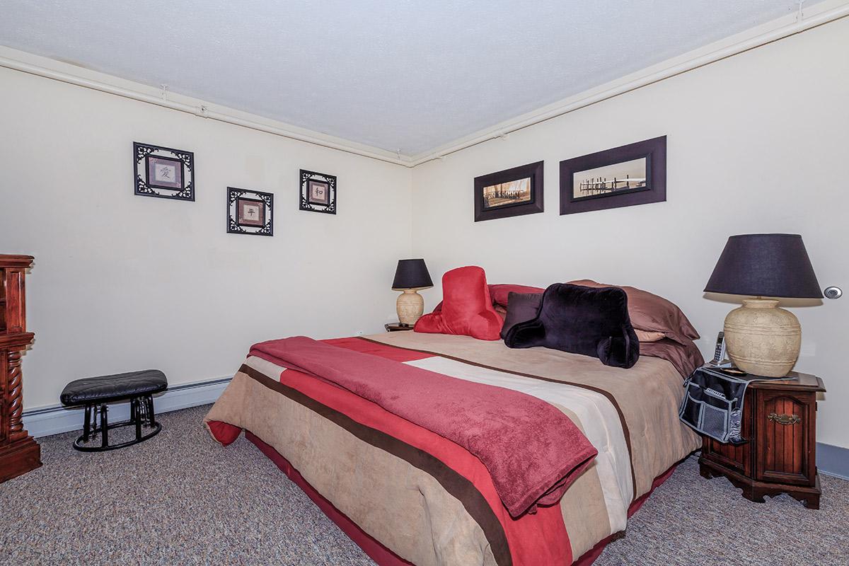 a bedroom with a large red chair in a room