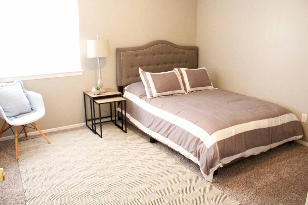 a bedroom with a bed and desk in a hotel room