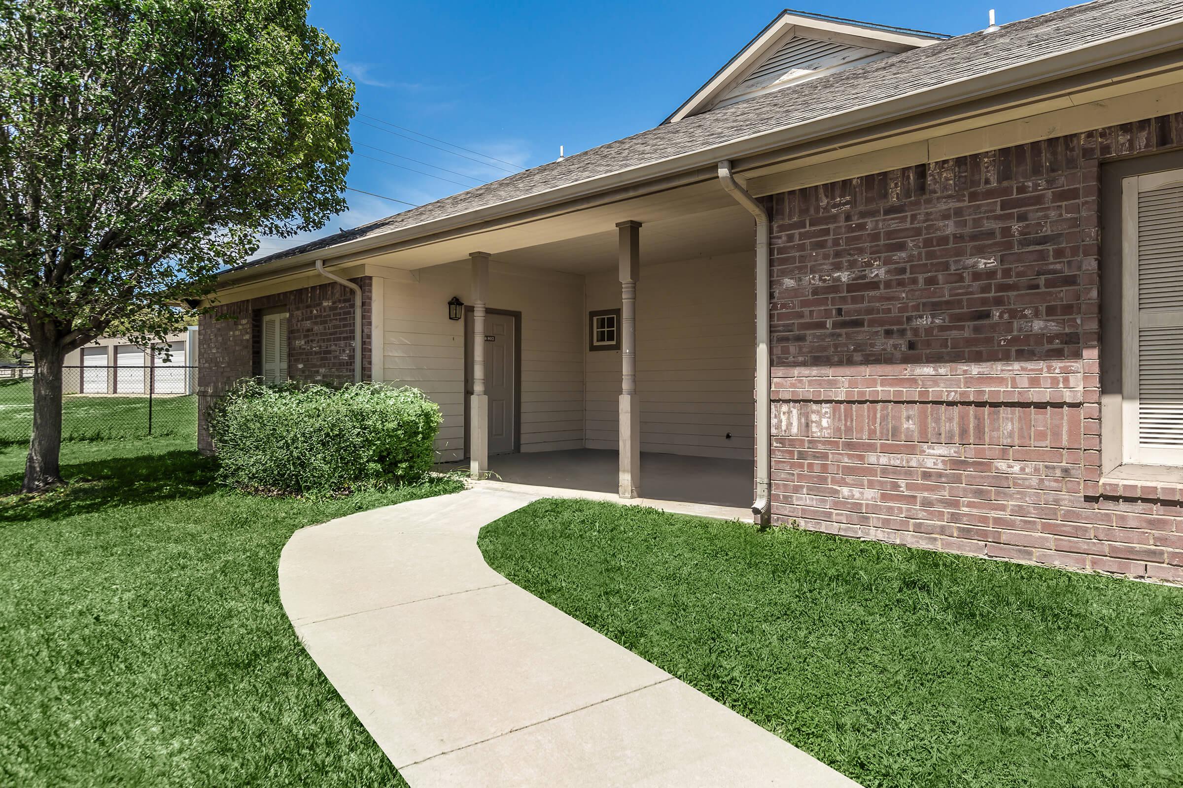 a large lawn in front of a brick building